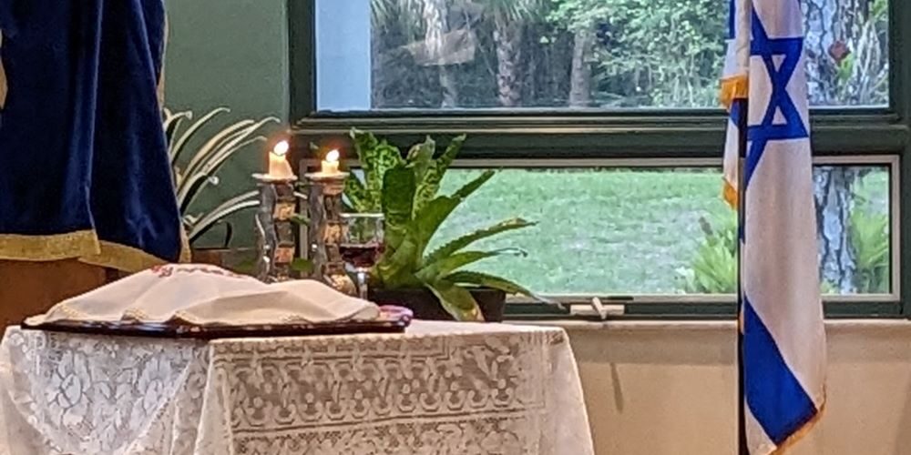 The Candles, the Challah and the wine and the presence of the Israeli flag—confirms and underscores the deep-rooted significance of Shabbat within the congregation and the strong solidarity with Israel.